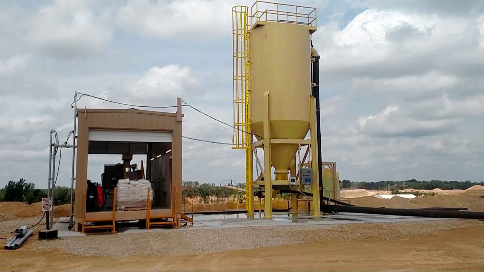 Técnico inspeccionando una planta de tratamiento de aguas residuales modular de color verde marca BIOMAX SYNERTECH, que incluye módulos de pretratamiento, decantación, DAF y oxidación avanzada. La planta está ubicada en un entorno industrial con techo alto y tuberías visibles. - ver más información